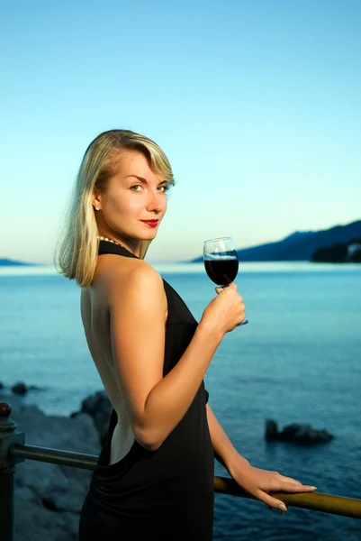 ワインのガラスの海の近くの美しい若い女性 — ストック写真