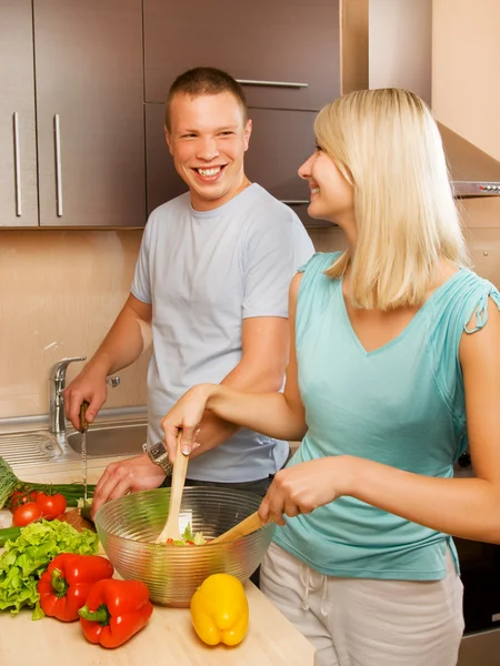 年轻的夫妇在厨房里做蔬菜沙拉 — 图库照片