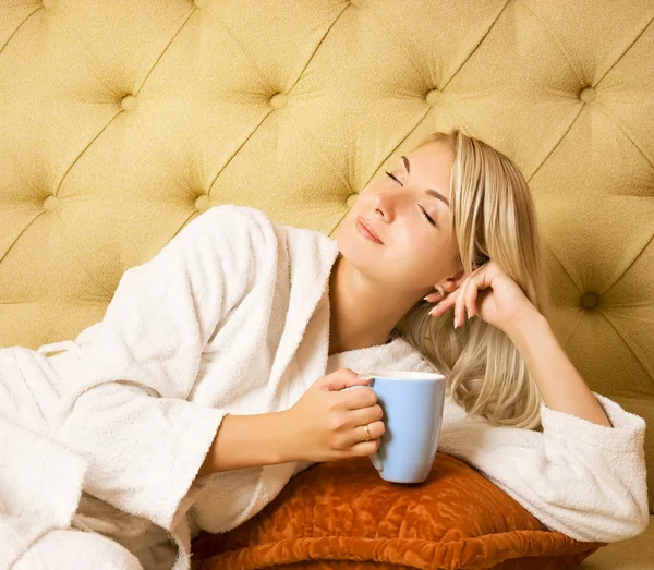名園の若い女性がベッドの上に座っていると 朝のコーヒーを飲む — ストック写真