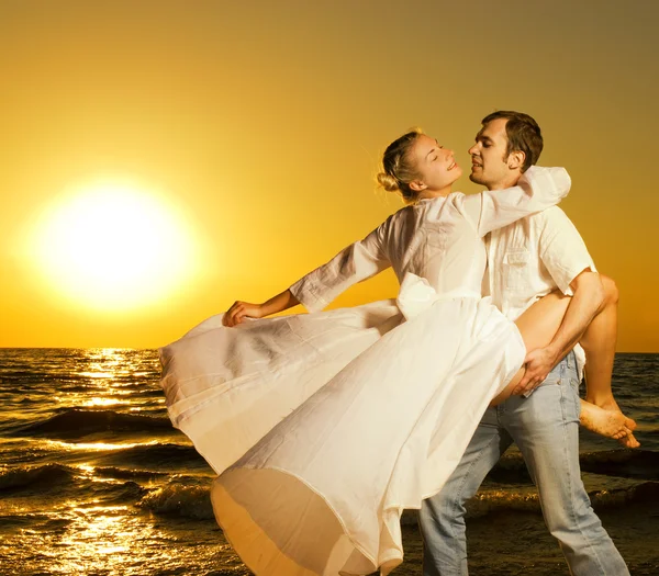 美丽的年轻夫妇在日落时的海滩上跳舞 — 图库照片