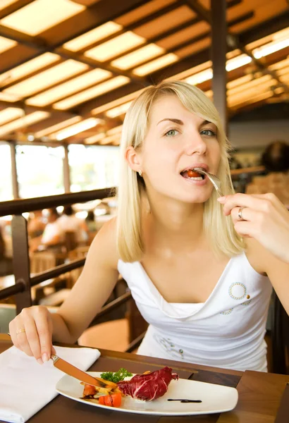 Mulher bonita comendo comida vegetariana em um restaurante — Fotografia de Stock