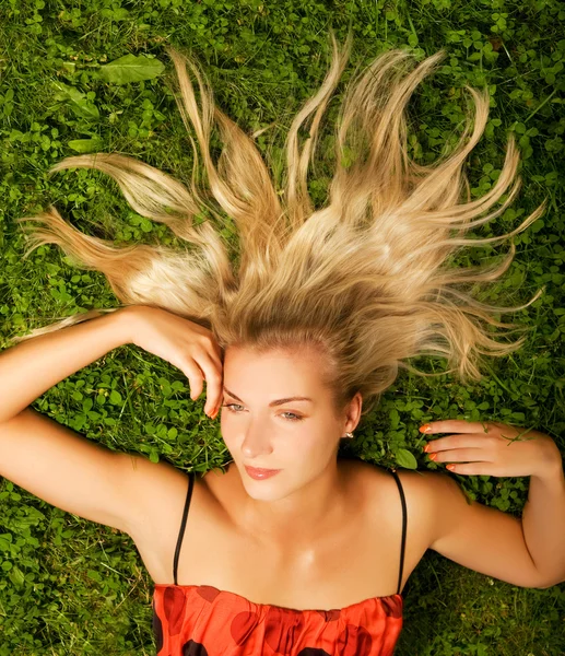Mujer joven relajándose en un prado — Foto de Stock
