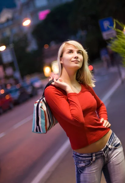 Schöne junge Frau in einer Stadt bei Nacht — Stockfoto