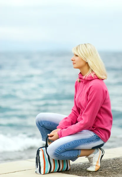 Θλιβερή γυναίκα που κάθεται κοντά στον ωκεανό — Φωτογραφία Αρχείου
