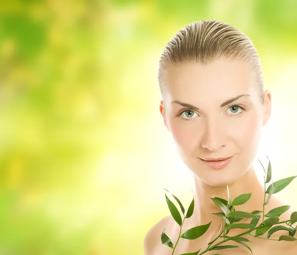 Hermosa mujer joven con planta verde sobre bac borrosa abstracta —  Fotos de Stock