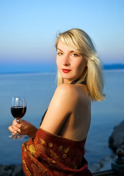 Mulher bonita bebe vinho tinto perto do oceano — Fotografia de Stock