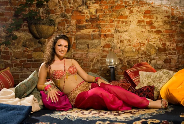 美丽的女人坐在枕头上的阿拉伯文服装 — 图库照片