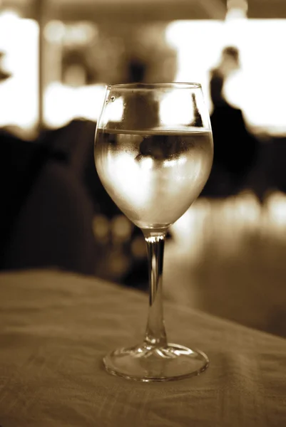 Glass of white wine on a table (toned in sepia) — Stock Photo, Image