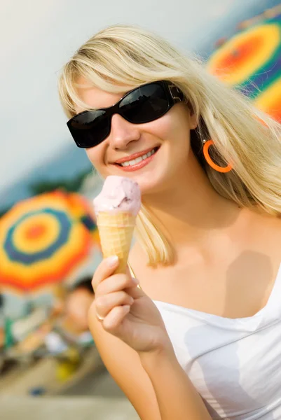 美丽的年轻女子在沙滩上吃冰激淋 — 图库照片
