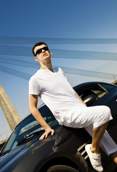 近代的なスポーツ車の近くに立っているハンサムな男 — ストック写真