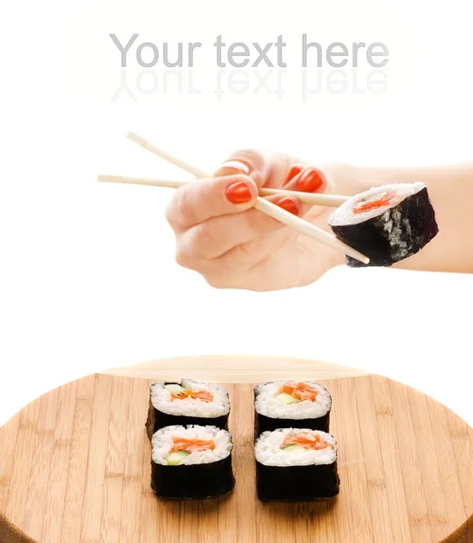 Χέρι που κρατά το Μάκη σούσι με ξύλινων chopsticks — Φωτογραφία Αρχείου
