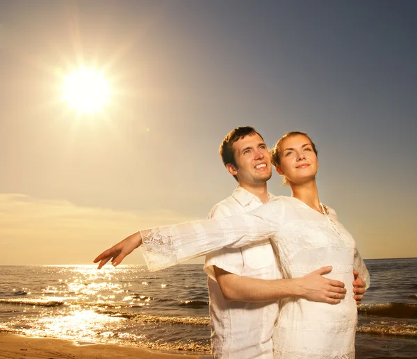 美丽的年轻夫妇轻松附近海域在日落时 — 图库照片