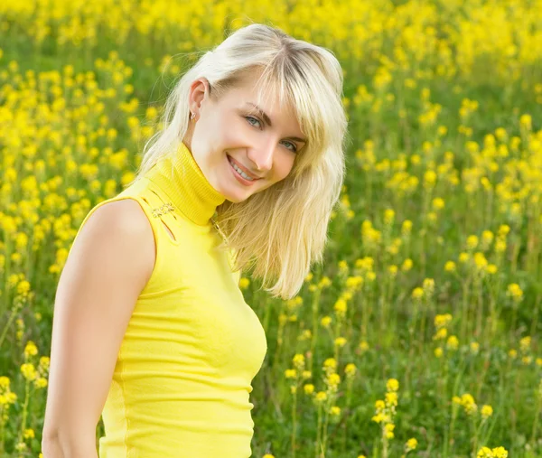 Schöne junge Frau in einem Blumenfeld — Stockfoto