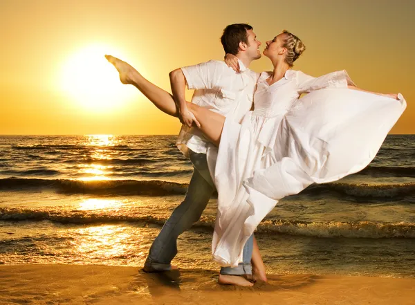 Bella giovane coppia ballare tango sulla spiaggia al tramonto — Foto Stock