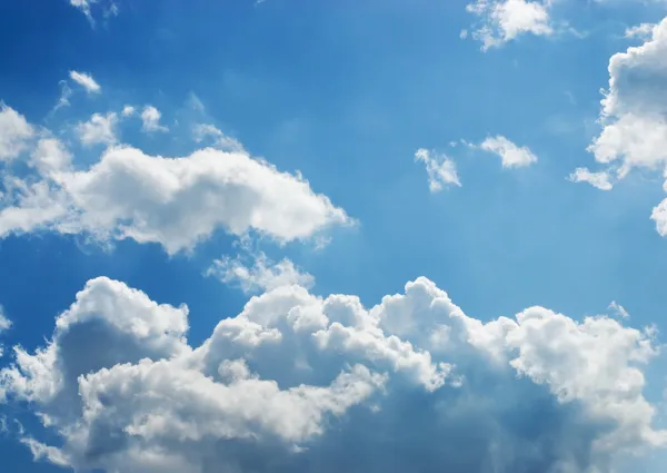 Nuvens cúmplices brancas e escuras brilhantes com um céu azul em t — Fotografia de Stock