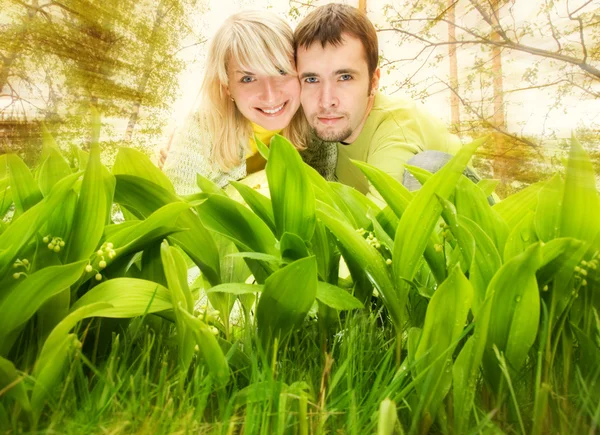 Jong koppel verbergen in verse groene gras — Stockfoto