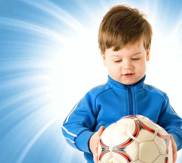 英俊的男孩与足球球在抽象的蓝色背景 — 图库照片