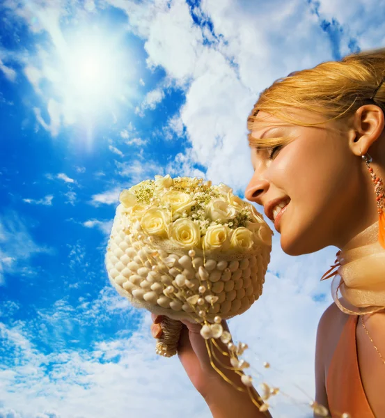 Красива руда дівчина з букетом квітів над хмарним небом — стокове фото