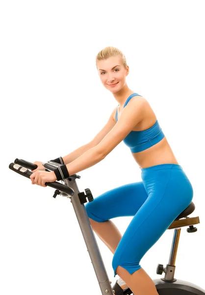 Vacker ung kvinna på träningscykel över vit bakgrund — Stockfoto