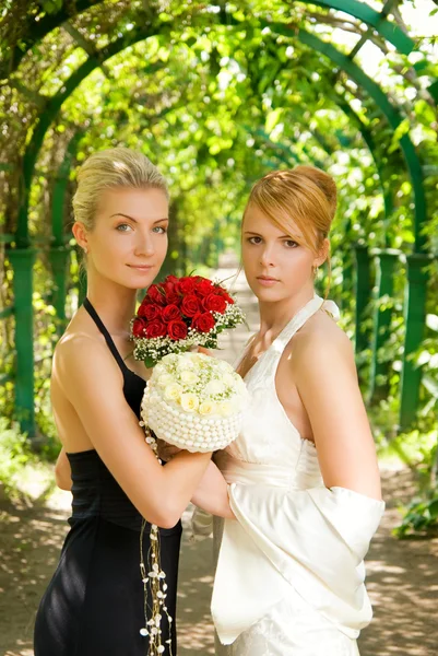 緑の路地で花を持つ二人の女の子 — ストック写真