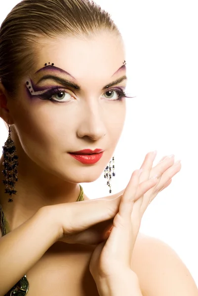 Красивая молодая женщина с творческим макияжем на лице — стоковое фото
