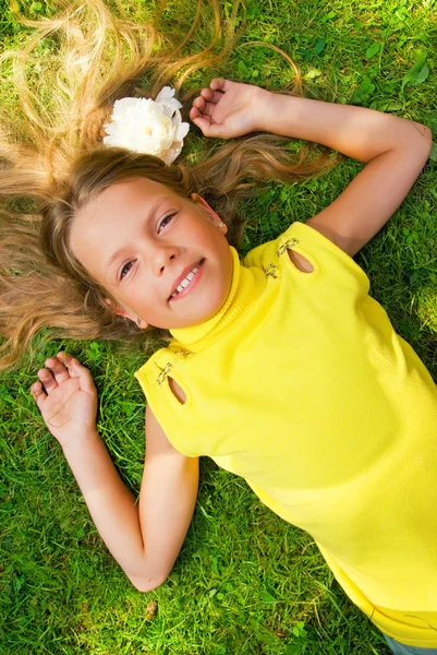 快乐的年轻女孩躺在绿草地上 — 图库照片