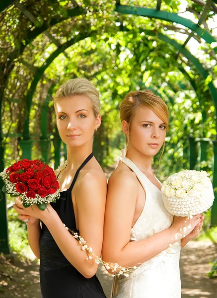 两个女孩与花在绿色的巷子里 — 图库照片