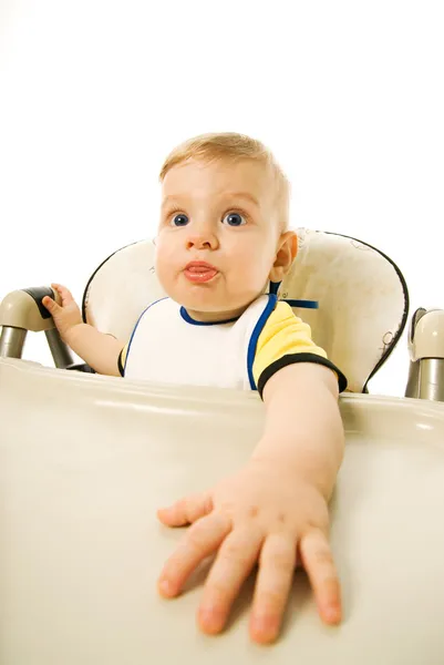 Bebê com fome sentado na cadeira de comer isolado no fundo branco — Fotografia de Stock
