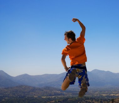 Happy guy jumping in mountains clipart