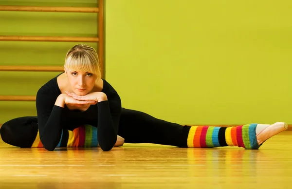 Танцовщица балета делает упражнения на полу — стоковое фото