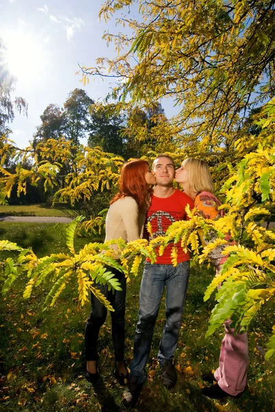 Две девушки целуются с одним парнем — стоковое фото