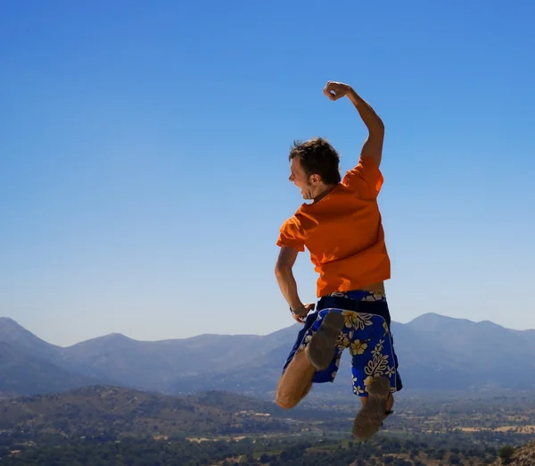 Glücklicher Kerl springt in die Berge — Stockfoto