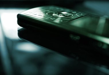 Blue/green toned picture of a mobile phone (shallow DoF, focused clipart