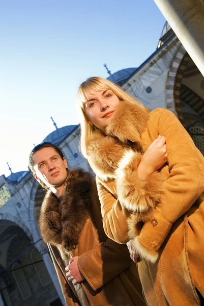 Casal atraente em casacos de pele de cordeiro — Fotografia de Stock