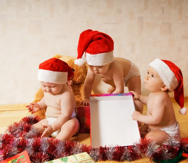 Grupo de crianças adoráveis em Natal chapéus presentes de embalagem — Fotografia de Stock