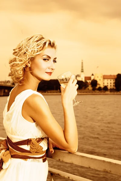 Güzel Sarışın Kız Nehir Kenarında Günbatımı Zaman Şampanya Içer — Stok fotoğraf