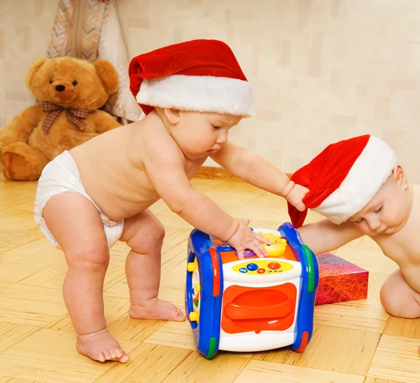 Noel şapka içinde iki güzel bebek — Stok fotoğraf