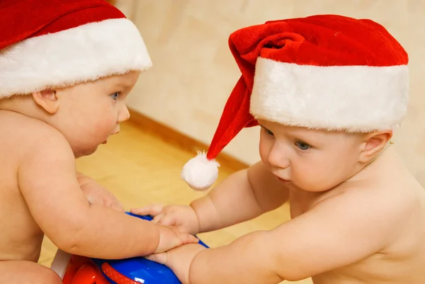 Dois belos bebês em chapéus de Natal — Fotografia de Stock