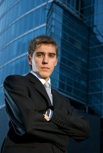 Jeune homme d'affaires confiant posant devant un immeuble de bureaux — Photo