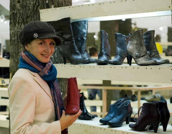 Güzel bir kız kışlık botlar satın almadan bir dükkan — Stok fotoğraf