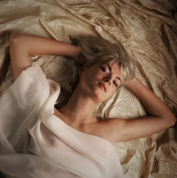 可爱美丽的金发女孩躺在床上的肖像 — 图库照片