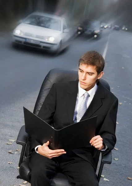 Bonito homem de negócios sentado na cadeira executiva em uma estrada — Fotografia de Stock
