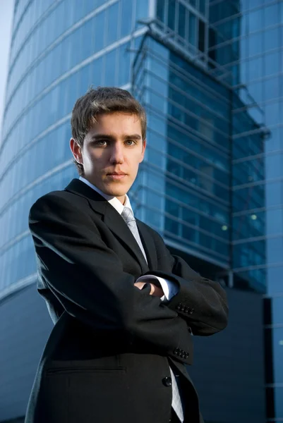 Jeune homme d'affaires confiant posant devant un immeuble de bureaux — Photo