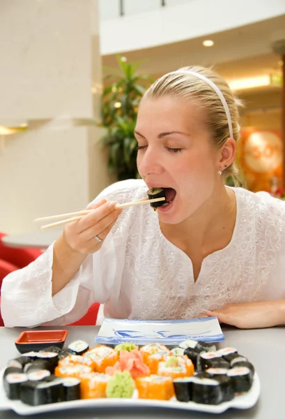 女の子はレストランで寿司を食べる — ストック写真