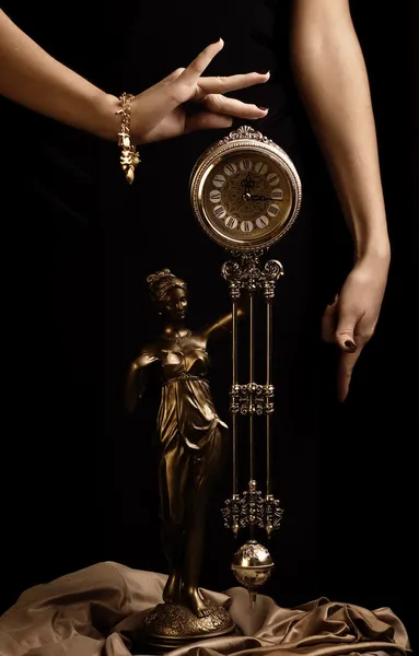 Yong flickans händer och antik klocka — Stockfoto