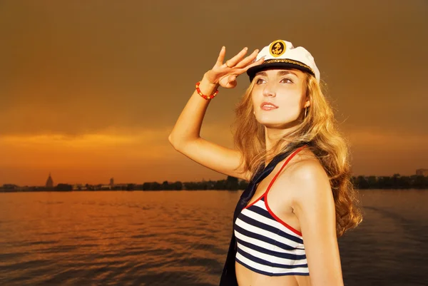 Mooi meisje in captain's hoed op zoek naar iemand — Stockfoto