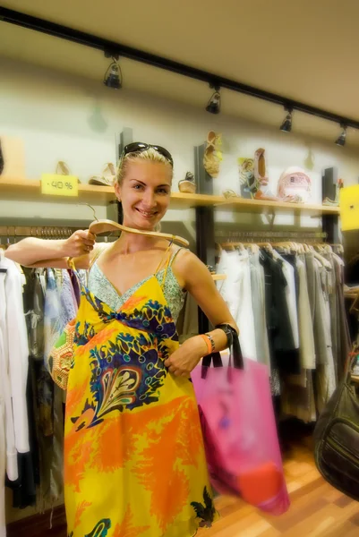 Chica Blong comprando ropa en una tienda — Foto de Stock