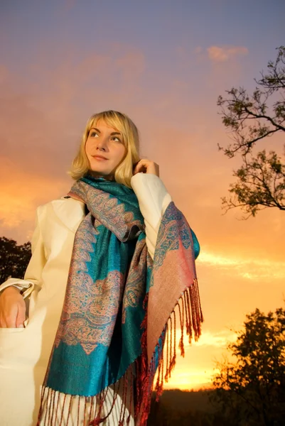 Blond girl on sunset sky background — Stock Photo, Image