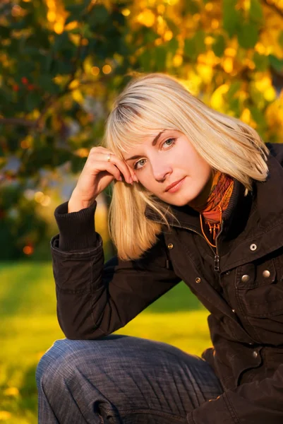 Prachtige blond meisje op herfst achtergrond — Stockfoto