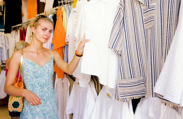 Ξανθιά κοπέλα αγοράζοντας ρούχα σε ένα κατάστημα — Φωτογραφία Αρχείου